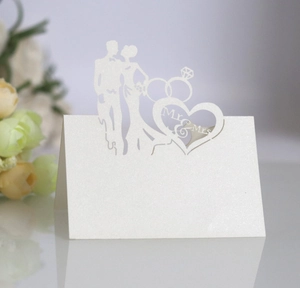 Macro detail of laser-cut Mr & Mrs heart pattern on white glittery pearlescent table card