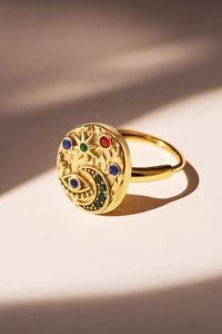 Macro detail of gold celestial ring with colorful zircon sun moon and evil eye relief