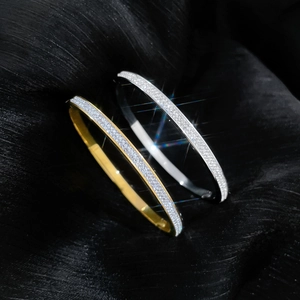 Macro shot of gold and silver titanium steel bracelets with full micro-pave crystals