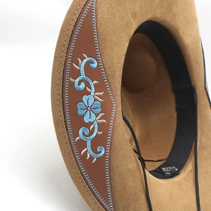 Close-up of western cowboy hat with detailed blue floral embroidery on brown suede brim