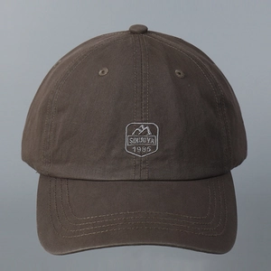 Close-up of brown cotton baseball cap with embroidered SIMJOYA 1985 mountain patch