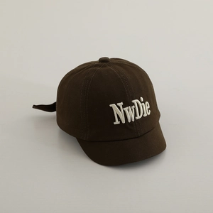 Close-up of deep brown kids baseball cap with premium NwDie 3D letter embroidery detail