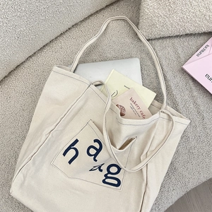 Top view of cream canvas tote bag showing large capacity for laptop and books