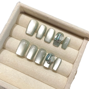 Handmade cat eye press-on nails with 3D floral accents and rhinestones in jewelry box