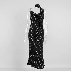 Detail of polka dot maxi dress featuring draped neckline and matching fabric neck tie