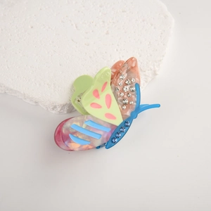 Close-up of butterfly hair claw clip with colorful patterns and sparkling rhinestones