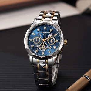 Detailopname van zakelijk horloge met blauwe wijzerplaat en goudkleurige stalen band