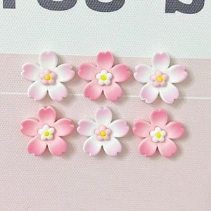 Close-up of pink and white resin cherry blossom charms for DIY accessories and crafts
