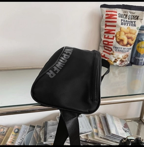 Détail d'un sac bandoulière fonctionnel noir avec imprimé POWER gris et sangle