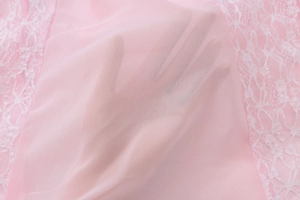 Detail of pink lace patchwork fabric with sheer mesh showing translucent texture