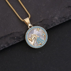 Macro detail of 18K gold Aquarius zodiac pendant with blue beads and shell inlay