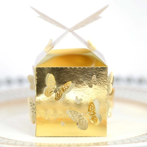 Details der goldenen Schmetterling-Süßigkeitenbox auf einem dekorativen Porzellanteller