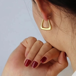 Gold plated geometric trapezoid stainless steel earrings worn on a female model
