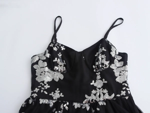 Detailaufnahme der eleganten silbernen Blumen-Paillettenstickerei auf dem Abendkleid