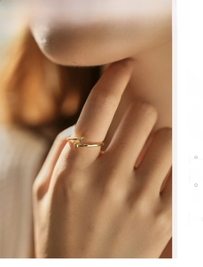 Detail of adjustable gold ring with blue evil eye stone and bead on model finger