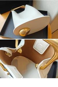Close-up of leather bucket bag featuring unique gold pebble hardware and suede lining