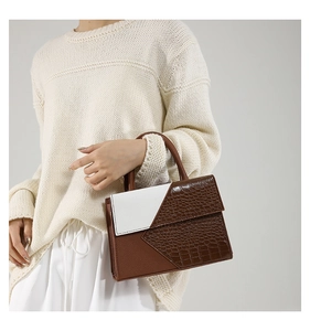 Détail du motif crocodile et texture litchi sur le sac bicolore marron et blanc