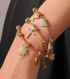 Close-up of 18k gold plated layered bracelets with heart and sea creature pendants