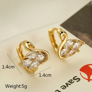 Detailed macro view of gold-plated swan earrings with marquise-cut cubic zirconia and stud closure