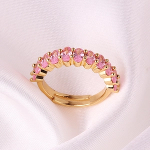 Detail of gold-plated adjustable ring featuring row of oval pink cubic zirconia stones