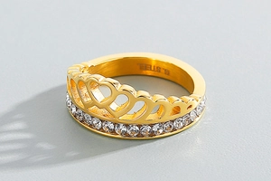 Close-up of a gold-plated stainless steel crown ring with white cubic zirconia stones