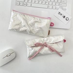 Détail de la trousse matelassée à nœud avec fermeture par ruban en satin rose