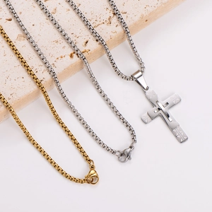 Three-layer stainless steel hip-hop necklace with cross pendant on beige stone slabs
