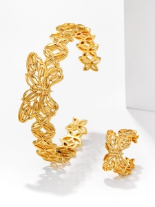 Detailed view of gold plated bangle and ring featuring intricate carved butterfly patterns