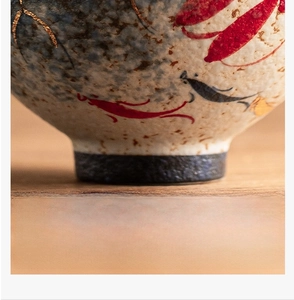 Macro shot of ceramic tea cup bottom featuring hand-painted koi fish and gold leaf detail