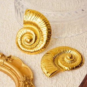 304 stainless steel gold conch pendants with spiral texture on a beige background