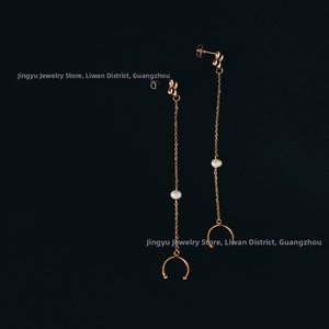 Detail view of rose gold tassel earrings with clover motif, white pearl and circular pendant