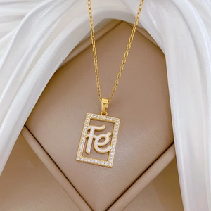 Luxurious gold square pendant necklace with pave crystals and Fe letter on silk