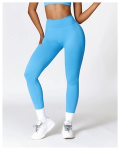 Detail of high waisted compression yoga leggings in bright blue with seamless knit texture