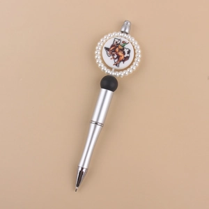 Dettaglio penna a sfera argento con mappa del Texas e medaglione cowboy con finte perle