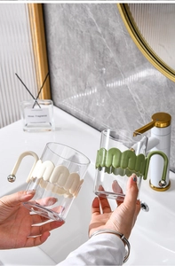 Transparent mouthwash cup with wavy silicone grip handle for home bathroom daily use.