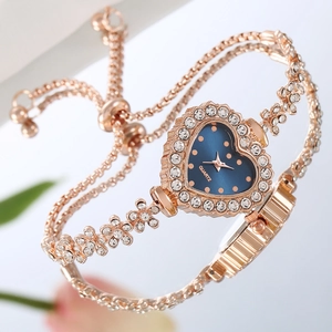 Montre cœur élégante en or rose avec bracelet fleurs diamant et cadran bleu sur reflet