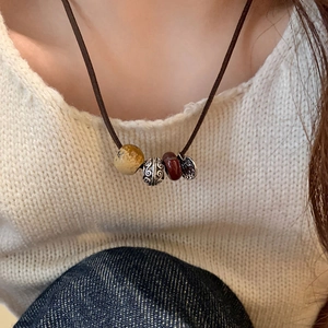 Primer plano de un collar trenzado de estilo étnico con cuentas de colores sobre punto blanco