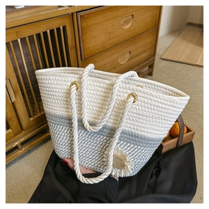 Detail of woven sunflower on beige and gray cotton rope tote bag with gold metal eyelets