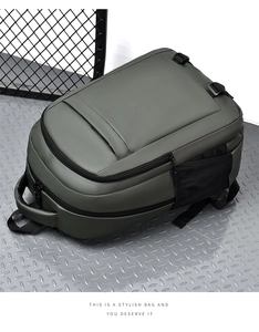 Close-up of military green waterproof backpack with mesh side pocket on industrial floor