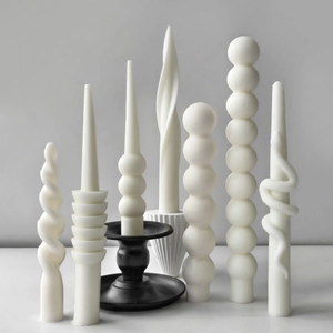 Artistic variety of spiral and textured white candles displayed on elegant holders