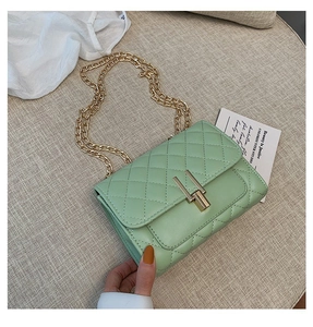 Detail shot of mint green quilted leather bag with golden U-shaped lock and chain strap