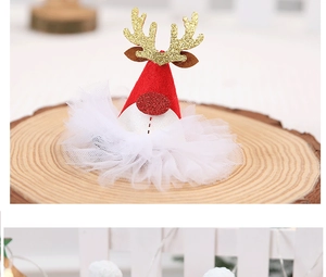 Detailed close-up of a Christmas hair clip featuring glittery golden antlers and red hat