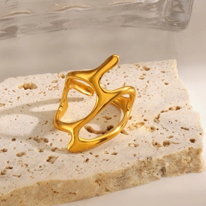 Irregular gold lava-style stainless steel open ring on natural travertine stone