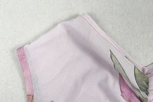 Close-up of elegant lavender floral print on sheer mesh fabric with fine stitching details
