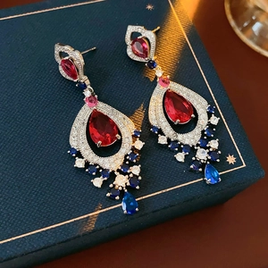 Macro view of vintage teardrop earrings with red and blue crystals in silver setting