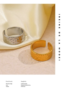 Detail of gold and silver hammered metal rings with bead borders on silk and stone