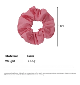 Detail view of 14cm pink fabric scrunchie showing measurements and soft pleated texture
