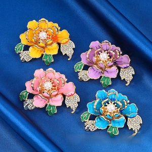Set of four colorful peony brooches with enamel petals and pearls on dark blue silk