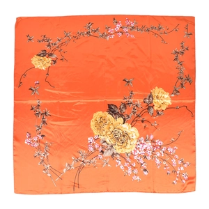 Dettaglio di un foulard in seta arancione con rose gialle e motivi floreali