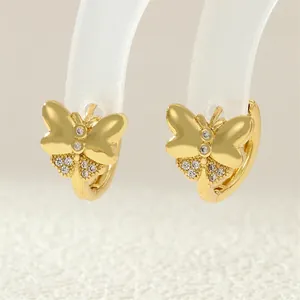 Macro view of gold-plated butterfly earrings featuring sparkling zircon and a hoop closure